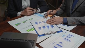 Business team analyzing financial data on documents with charts and graphs during a meeting - Powered by Shutterstock - Get 15% off with code: PIKWIZARD15