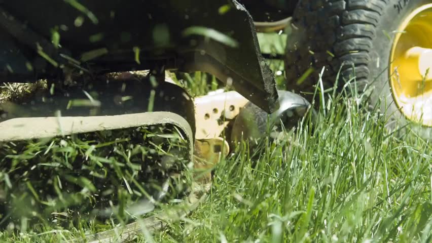 Lawn mower blades cutting grass in slow motion, capturing precision, outdoor maintenance, and vibrant green lawn care in 4K.