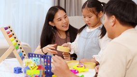 Parents and daughter interact with colorful educational toys in a bright, cozy living room setting - Powered by Shutterstock - Get 15% off with code: PIKWIZARD15
