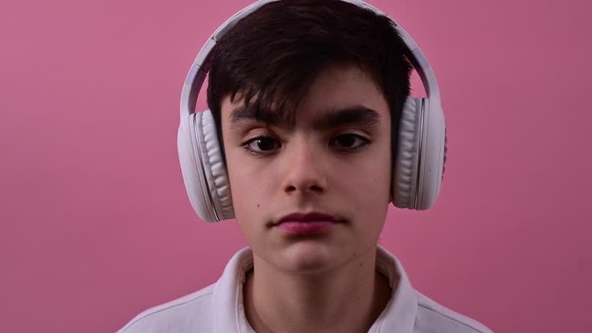 Teenage boy dancing and enjoying music with wireless headphones