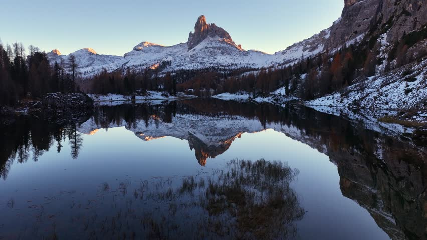Drone flying in snowy Alpine lake in the Italian Dolomites in winter with snowcapped peaks, drone view of Lake Federa, Dolomites, Italy. Lake Federa and the Cortina valley. . High quality 4k footage