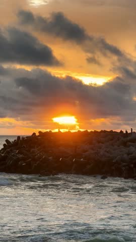 Dramatic Sunset Over Ocean Rocks - A Coastal Serenity.