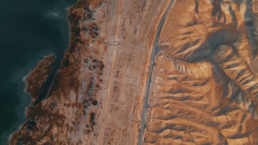 Top View Drone Shot: Two Cars on Desert Road Between Judean Hills and Dead Sea at Sunrise