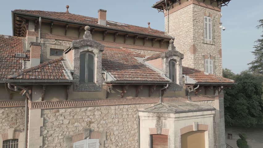 Drone Vertical Ascent Revealing Historic Stone Mansion and Rooftops in Southern France