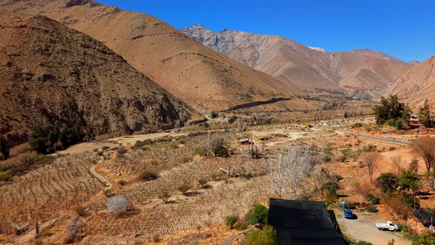 Aerial view of arid mountains in the Elqui Valley in northern Chile, orange groves and desolate landscapes