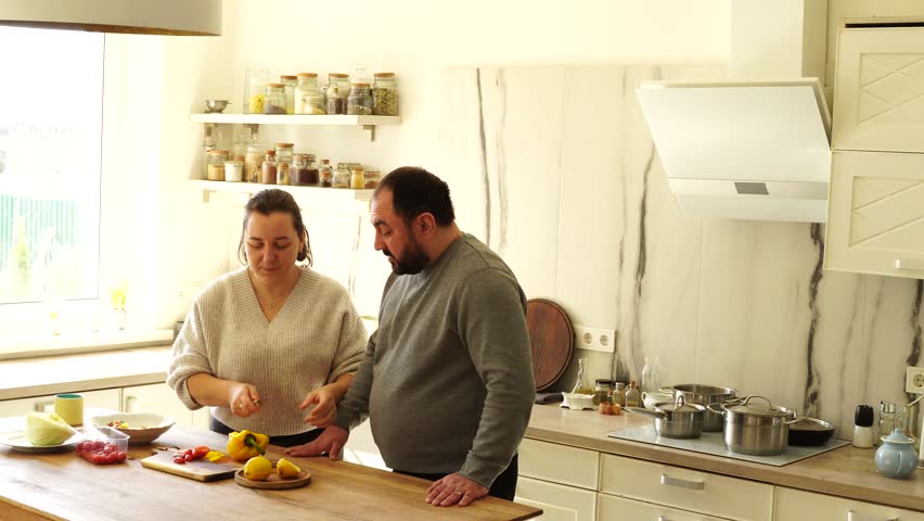 Couple at the kitchen have time together and cooking

