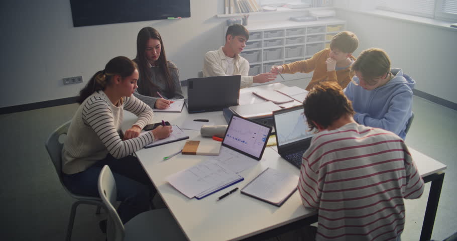 Group of Teenagers Gather Around Laptops and Tablets, Discussing Ideas and Sharing Insights. Concept of Collaborative Education, Digital Literacy, and Innovation in Contemporary Learning Spaces.