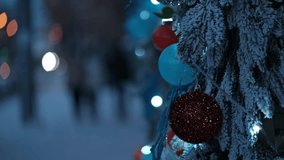outdoors festive christmas tree branches covered in snow, decorated with colorful baubles and twinkling fairy lights, creating magical winter holiday atmosphere with bokeh lights on street. close up. - Powered by Shutterstock - Get 15% off with code: PIKWIZARD15