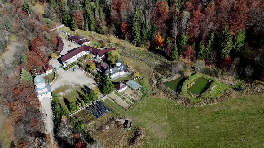 Aerial view of the Ascension of the Lord Monastery in Romania nestled within autumn forests