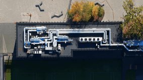 An Aerial top view of modern industrial rooftop with blue pipes, air ducts, and machinery - Powered by Shutterstock - Get 15% off with code: PIKWIZARD15