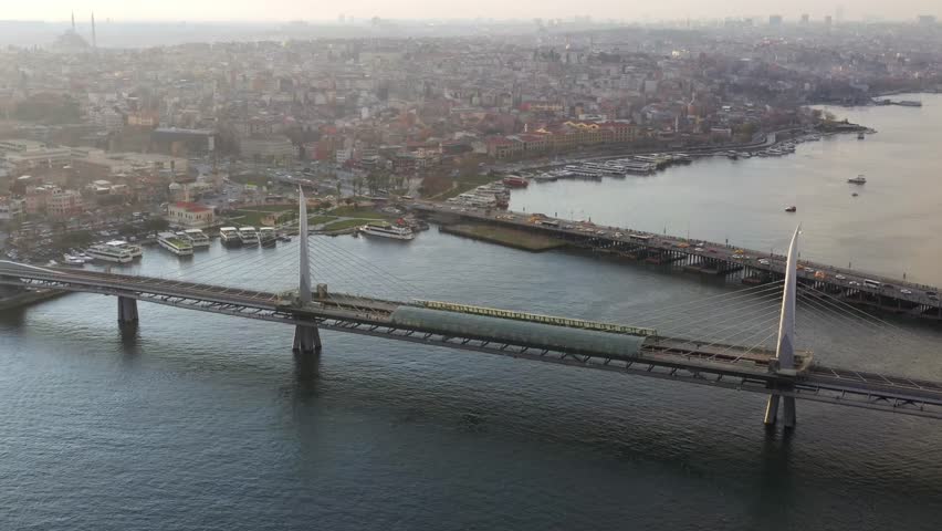 Aerial view of the Golden Horn Metro Bridge over the blue water, with the city hazy in the background, Istanbul, Istanbul, Turkiye.