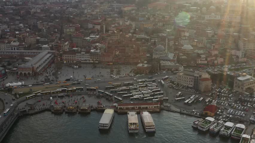 Aerial view of Eminonu Square bustling with ferries, buses, and people in a vibrant urban landscape by the water, Istanbul, Istanbul, Turkiye.
