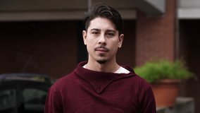 A young man with dark hair in a sweater smiles and waves, showing friendly interaction, casual greeting, and positive indoor communication. - Powered by Shutterstock - Get 15% off with code: PIKWIZARD15