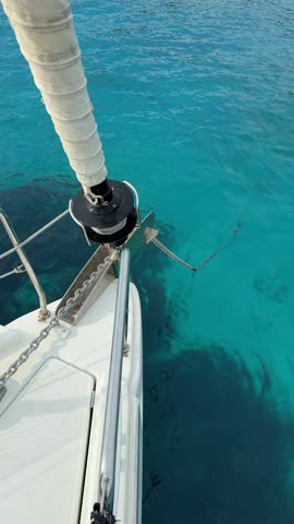 Automatic anchor chain retrieval on a yacht using a remote control during anchoring. Close-up of windlass system in action, detail from modern sailing life and nautical routine.