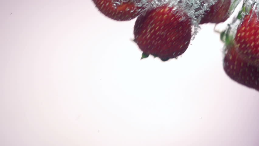 fresh strawberry dropped into water with splash on backgrounds