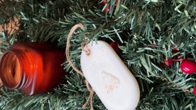 Close-up of Handmade Scented Wax Sachet on Christmas Wreath. The sachet is displayed resting against a rich green Christmas wreath or garland adorned with bright red berries - Powered by Shutterstock - Get 15% off with code: PIKWIZARD15