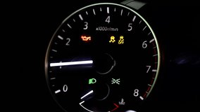 Close-up macro view of illuminated car dashboard showing tachometer, engine oil and traction control warning lights glowing in dark interior, symbolizing automotive technology and driving safety. - Powered by Shutterstock - Get 15% off with code: PIKWIZARD15