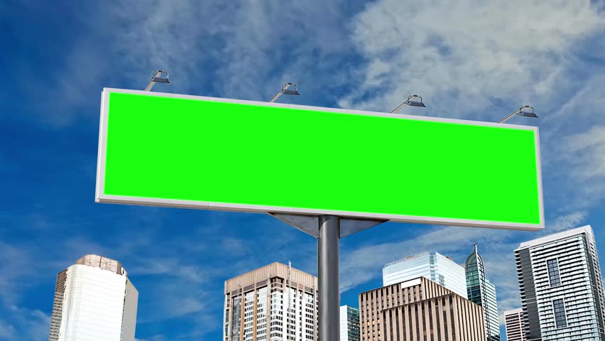 Large billboard with green screen for advertising on the wall of the building and a beautiful sky above