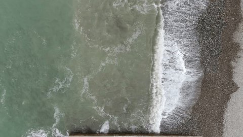 Aerial View of Waves Washing Over Pebble Beach