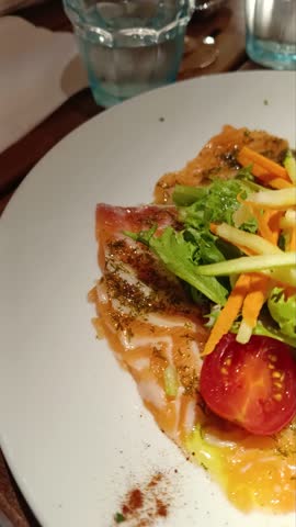 Fresh salmon carpaccio with marinated raw vegetables