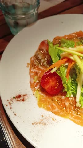 Fresh salmon carpaccio with marinated raw vegetables