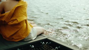 Close-up of a couple's bare feet splashing water while sitting on a lake pier. - Powered by Shutterstock - Get 15% off with code: PIKWIZARD15
