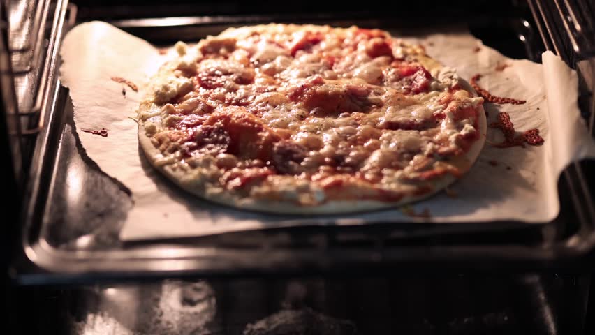 A delicious pizza baking inside a hot oven, with melting cheese bubbling on top and a golden-brown crust forming perfectly.
