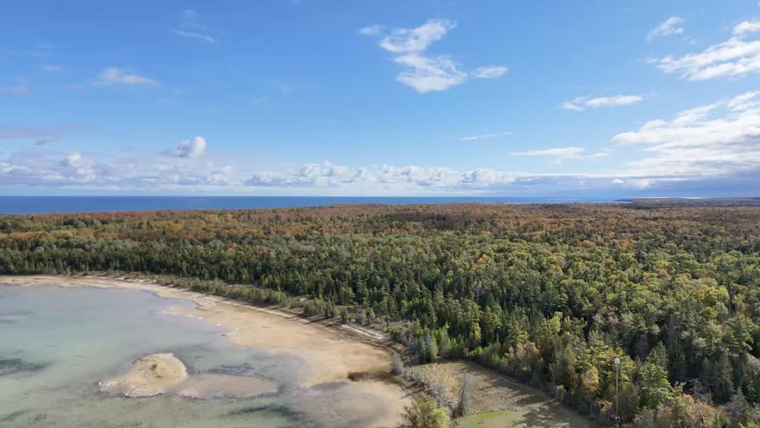 Aerial video of Jackson Harbor on Washington Island, Wisconsin, soaring toward Rock Island above the striking blue waters uniting Lake Michigan and Green Bay