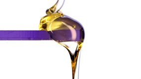 Golden viscous liquid flowing in macro on a white background. Thick syrup texture, slow smooth drip, glossy highlights and close-up fluid motion perfect for food, beauty, art and commercial visuals. - Powered by Shutterstock - Get 15% off with code: PIKWIZARD15