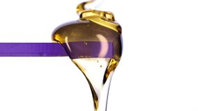 Golden viscous liquid flowing in macro on a white background. Thick syrup texture, slow smooth drip, glossy highlights and close-up fluid motion perfect for food, beauty, art and commercial visuals. - Powered by Shutterstock - Get 15% off with code: PIKWIZARD15