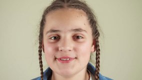 A girl with braided hair is smiling at the camera. She is wearing a blue shirt. The girl's hair is in two braids - Powered by Shutterstock - Get 15% off with code: PIKWIZARD15