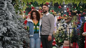 Happy couple choosing discounted Christmas tree and decorations at holiday market - Powered by Shutterstock - Get 15% off with code: PIKWIZARD15