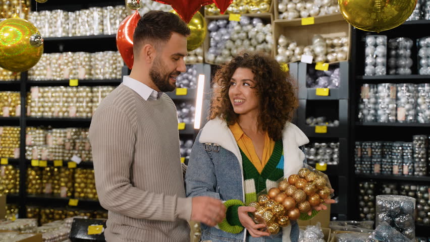 Happy young couple choosing Christmas ornaments together