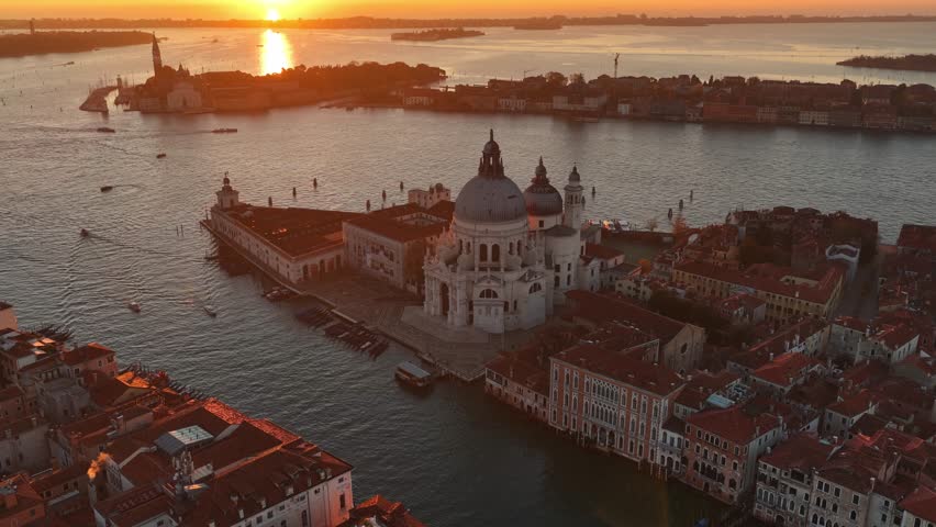 Drone shot of Venice old town, tourism in Italy. Basilica di Santa Maria della Salute, Grand Canal and lagoon. Venice skyline at sunrise. Establishing aerial shot of Venice