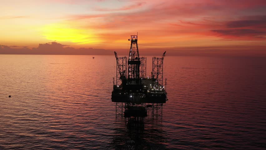 Aerial view of offshore jack up rig and offshore platform during sunset for oil and gas exploration and production. 
