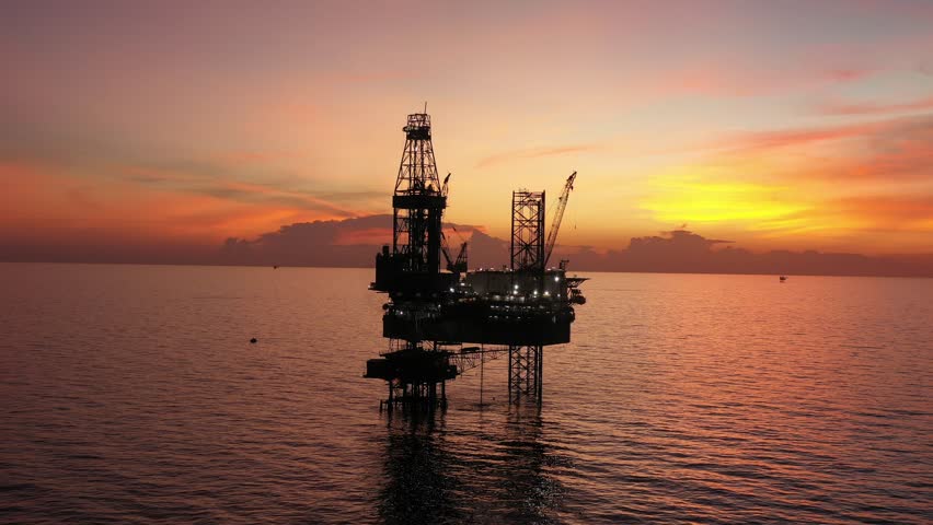 Aerial view of offshore jack up rig and offshore platform during sunset for oil and gas exploration and production. 
