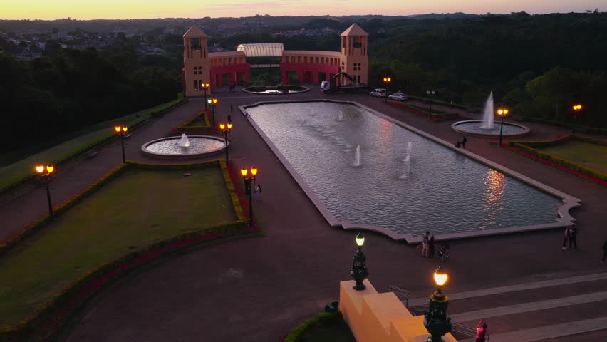Aerial footage of a public park in downtown Curitiba, Parana, Brazil, showing green areas, walking paths, trees, and surrounding urban buildings.