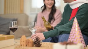 Young asian couple celebrating winter holidays at home, pouring red wine into a glass to drink - Powered by Shutterstock - Get 15% off with code: PIKWIZARD15