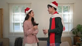 Happy young asian couple in santa hats celebrating christmas, toasting and drinking red wine at home - Powered by Shutterstock - Get 15% off with code: PIKWIZARD15