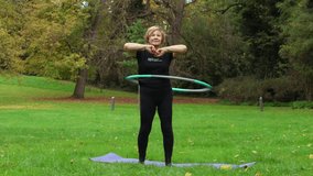 Senior woman hula hooping outdoors in autumn park - Powered by Shutterstock - Get 15% off with code: PIKWIZARD15