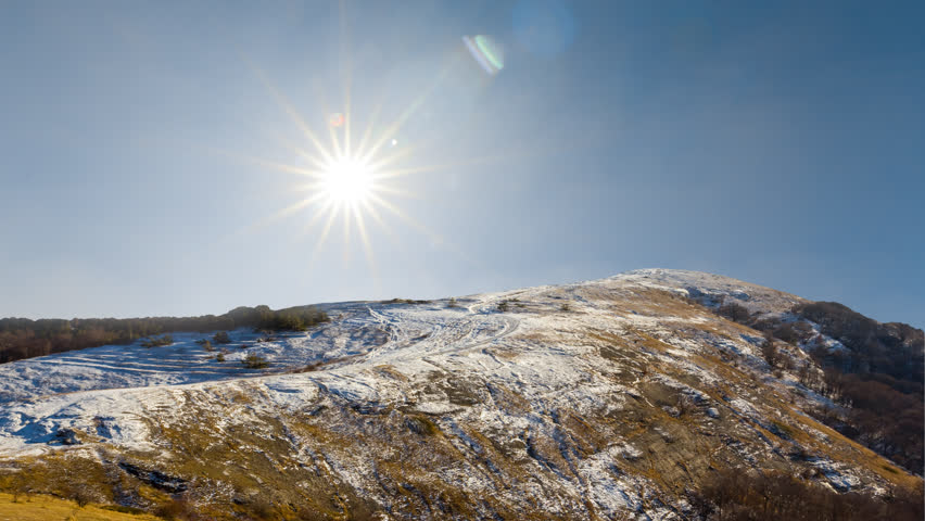 mount top in a snow under a sparkle sun, winter outdoor time lapse scene