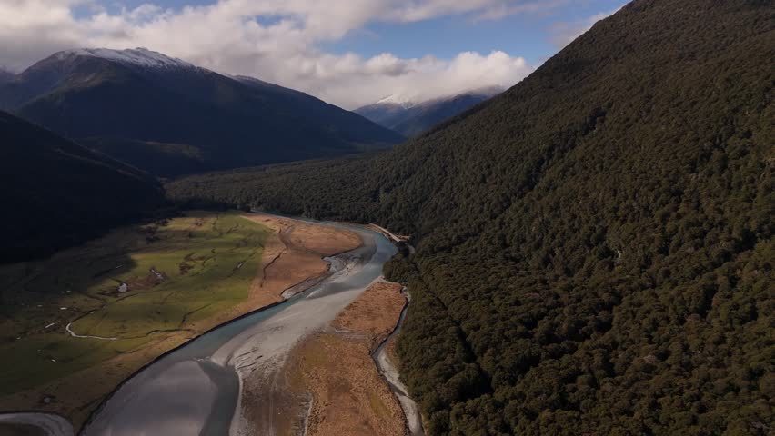 River crossing green valley, Mount Aspiring National Park, New Zealand. Aerial drone panoramic view