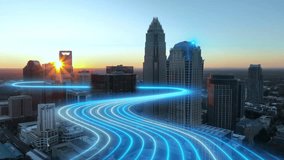 Sweeping aerial drone view of Charlotte city skyline at sunset with glowing network lines flowing over roads illustrating future smart city connectivity and energy data streams - Powered by Shutterstock - Get 15% off with code: PIKWIZARD15
