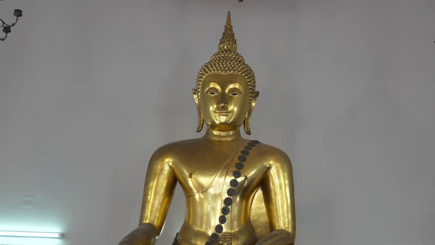 Golden Buddha statue inside Wat Pho temple, Bangkok, Thailand. The image highlights the serene expression and intricate details of Thai craftsmanship, symbolizing peace, enlightenment.