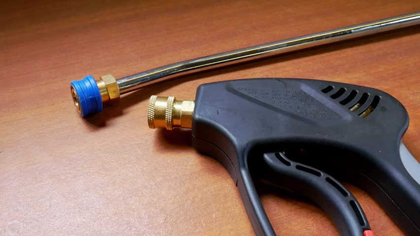 Top to bottom panning shot of pressure washer trigger gun with quick release accessories