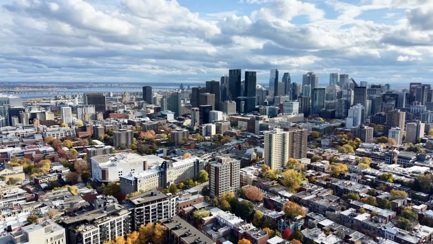 Autumn aerial view of Montreal downtown skyline with high-rise buildings under cloudy sky. g.