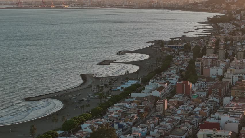Aerial view of Málaga, Spain coastline with curved beaches and urban landscape along the Mediterranean Sea. Scenic seaside cityscape, travel and tourism destination, summer coastal vibes.