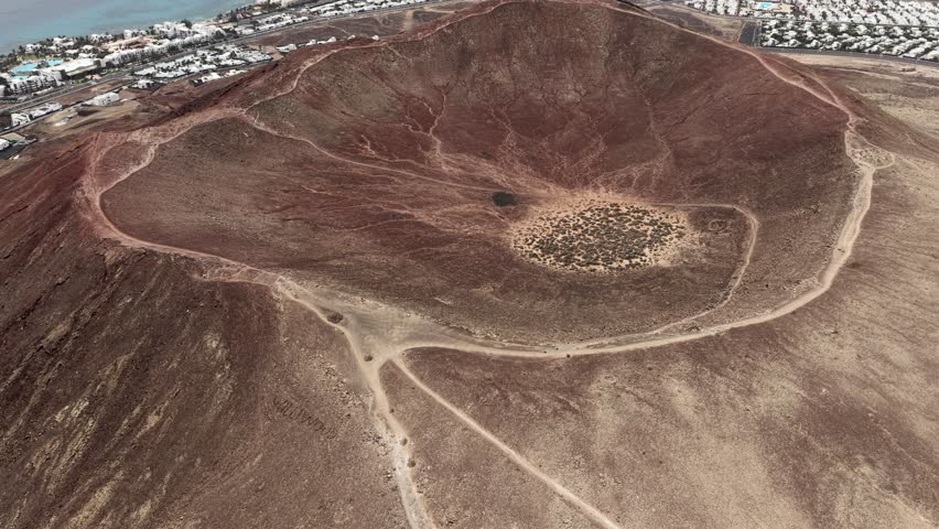 Vibrant Montana Roja aerial view circling the volcanic mountain top crater in Lanzarote