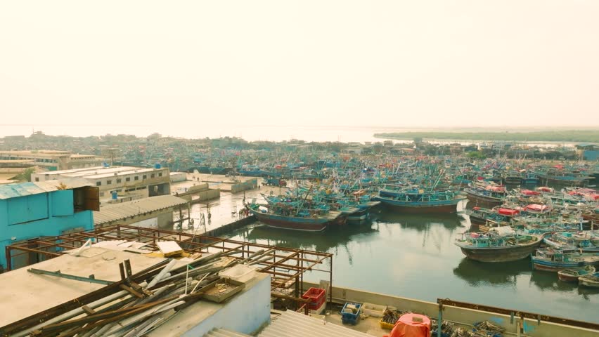 Dozens of Fishing Boats Docked in a Busy Harbor in Karachi City