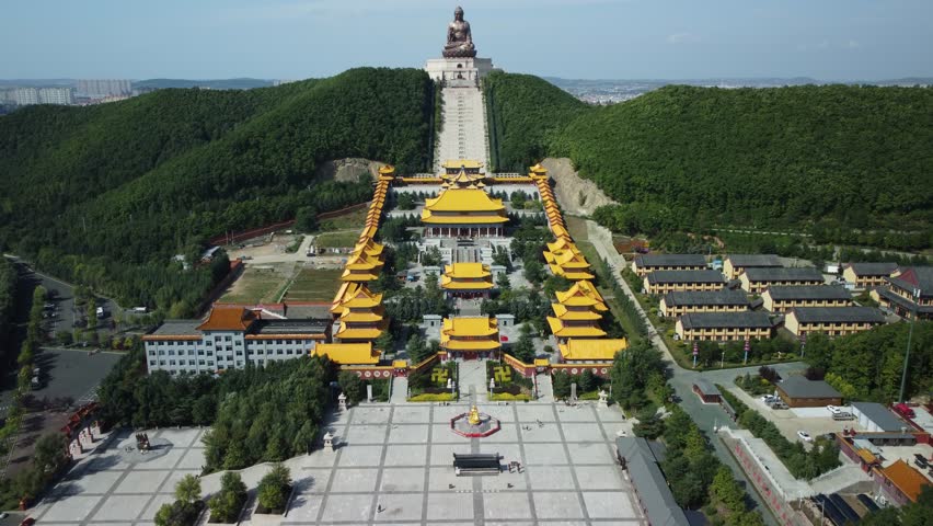 Aerial view of the Golden Buddha statue at Liudingshan Cultural Tourism Area in Dunhua City, Jilin Province, China. Massive golden statue overlooking Zhengjue Temple and facing the Changbai Mountain